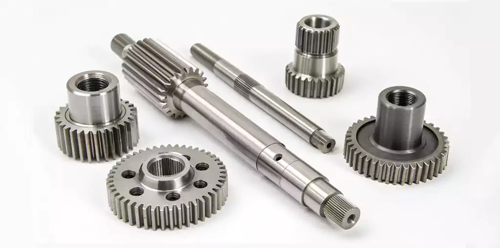 An assortment of precision CNC machined steel parts, including gears and shafts